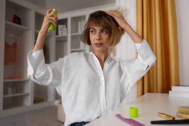 medium-shot-woman-using-dry-shampoo-home